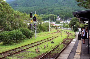 Yufuin istasyonunda treni bekliyor. Oita, Japonya 'da Haziran 2019' da çekildi..