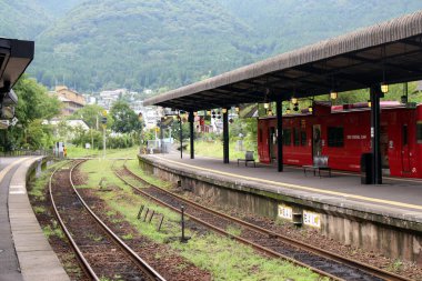 Japonya, Oita 'daki Yufuin İstasyonu' nda kırmızı tren duruyor. Haziran 2019 'da çekildi.