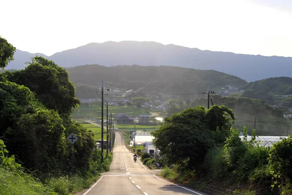 在以高山为背景的农村地区骑摩托车的人 2019年9月拍摄 — 图库照片