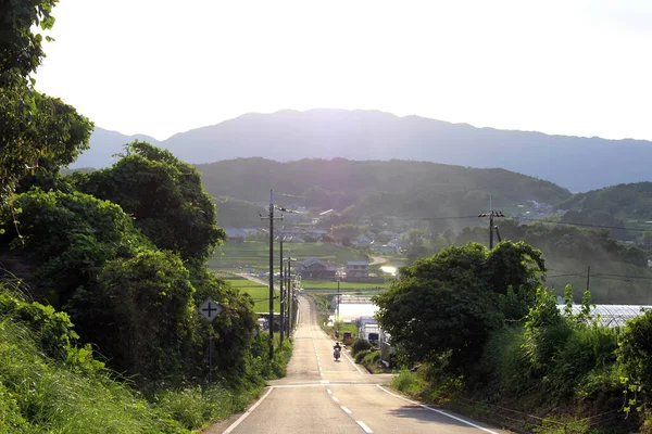 在以高山为背景的农村地区骑摩托车的人 2019年9月拍摄 — 图库照片