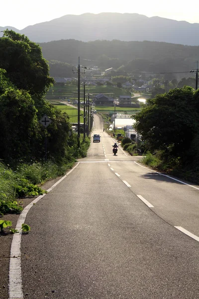 在以高山为背景的农村地区骑摩托车的人 2019年9月拍摄 — 图库照片