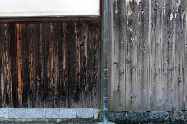 Japanese wall, wood planks, and pipe in Asuka village of Nara. Taken in September 2019.