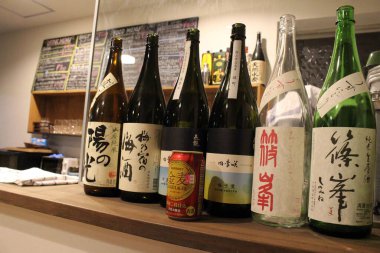 Japon sake şişelerinin arasında Suntory birası..