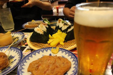 Japonya 'nın Nagasaki kentindeki Kaniya Honten restoranında onigiri veya pirinç topu ve bira servis edilir. Ağustos 2019 'da çekildi..