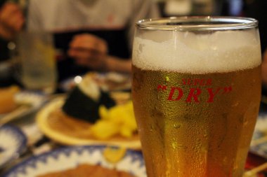 Nagasaki 'deki Kaniya Honten restoranının arka planında onigiri ile bir bardak 