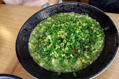 Bir kase domuz etli ramen tonkotsu dilimlenmiş taze soğan ya da Kagoshima 'da pırasa ile kaplı..