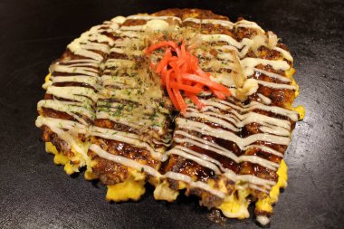 Okonomiyaki 'nin kapanışı, Japon pizzası tavada veya Teppan' da pişiriliyor..