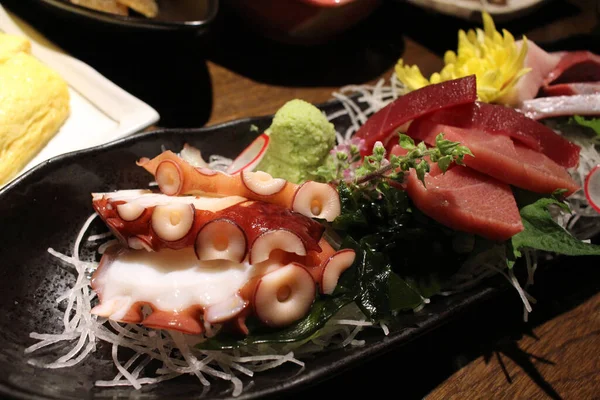 魚やタコが入った刺身が居酒屋で出されます — ストック写真