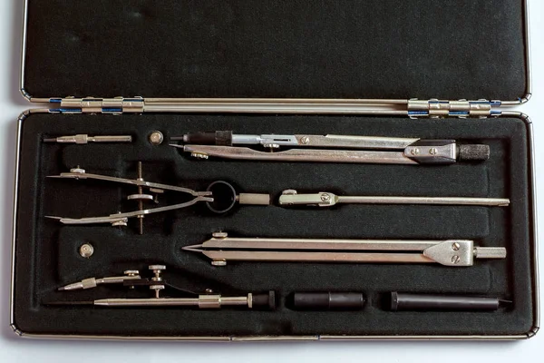 A set of drawing tools is in the special box with the lid open.