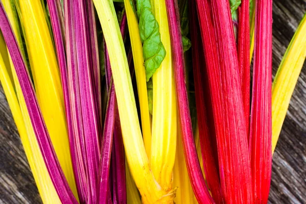 Harvest of colored chard (Beta vulgaris) on a wooden table
