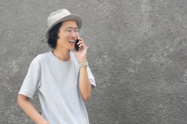 akıllı telefon kullanarak şapka ve gözlük ile çekici genç asyalı adam