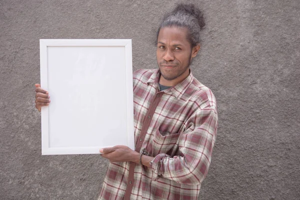 young bearded black man in casual dress holding white blank board