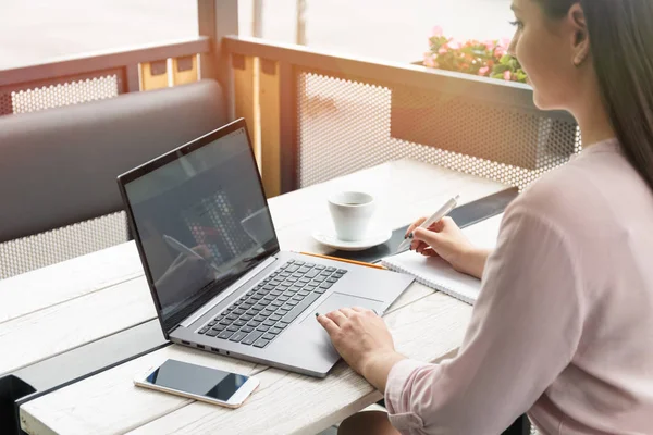 Laptop ve yazma, kahve tablo üzerinde çalışan genç bir kadın portresi kapatın.