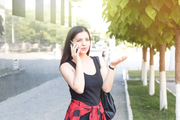 Atractiva morena estudiante femenina hablando en el teléfono móvil . — Foto de Stock