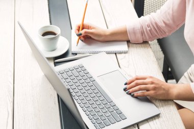 İş, eğitim, insan ve teknoloji kavramı - kadın el laptop, kağıt, masada kahve üzerine yazma çalışma yakın