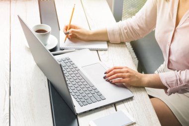 İş, eğitim, insan ve teknoloji kavramı - kadın el laptop, kağıt, masada kahve üzerine yazma çalışma yakın