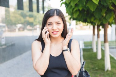 Şok bir genç kız parkta telefonda konuşan portresi