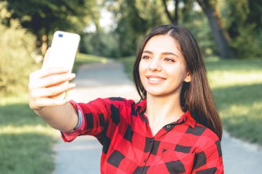 Selfie, video alarak güzel esmer kız kırmızı, ekose gömlekli, portresi sohbet