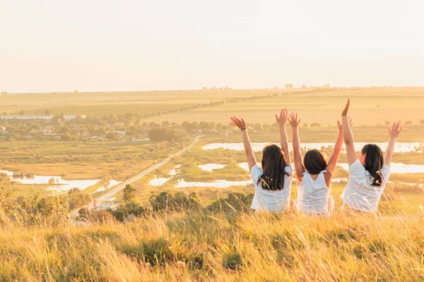 Üç kız kırsal bir tepe üzerinde güneşin tadını grubu