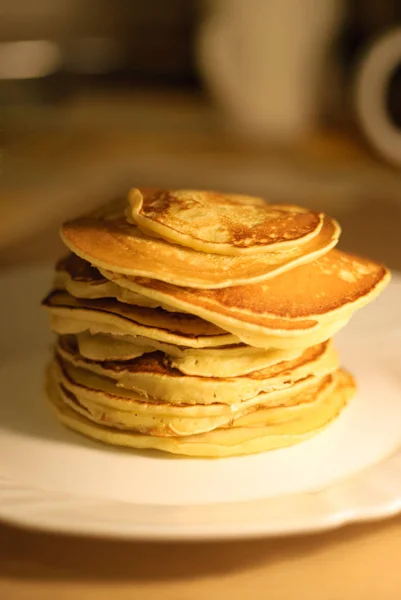 Tasty pancakes on white plate, kitchen background — Stock Photo, Image