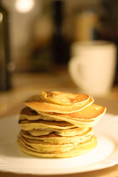 Tasty pancakes on white plate, kitchen background Stock Picture