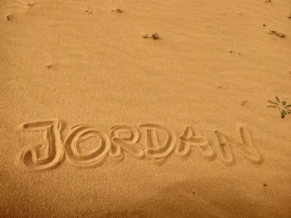 Jordan country name written in sand of Wadi rum desert