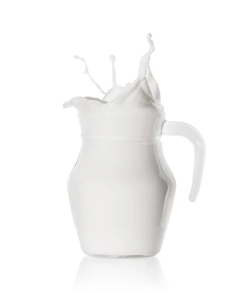 Splash of fresh milk in  glass jug — Stock Photo, Image