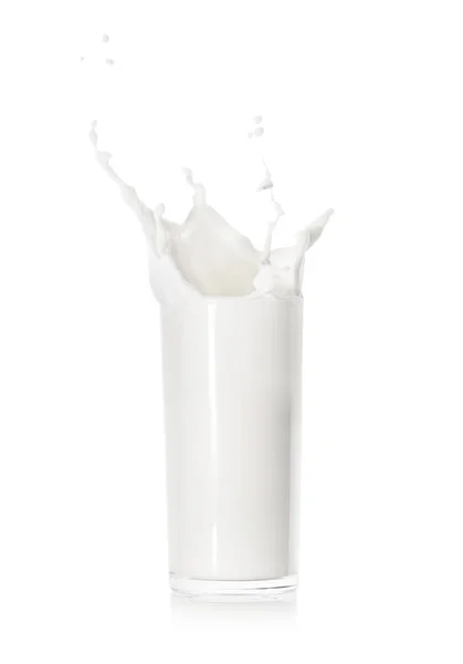 Spritzer frischer Milch in einem Glasbecher — Stockfoto