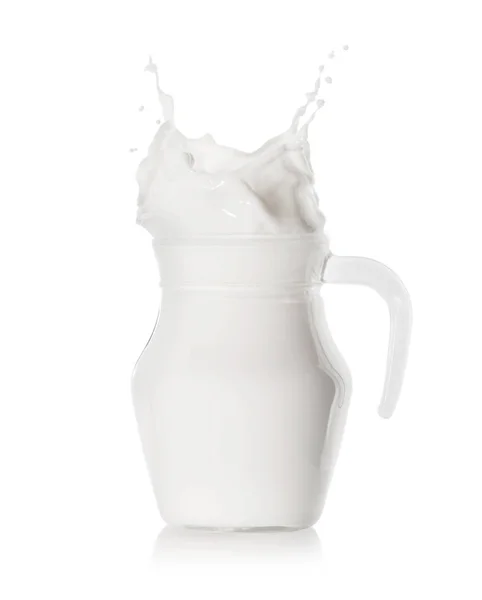 Schizzi di latte in una brocca di vetro ripiena — Foto Stock