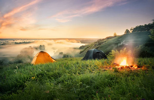Pomarańczowy namiot i ognisko nad rzeką mglisty — Zdjęcie stockowe