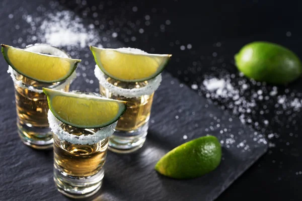 Goldener Tequila auf schwarzem Hintergrund — Stockfoto