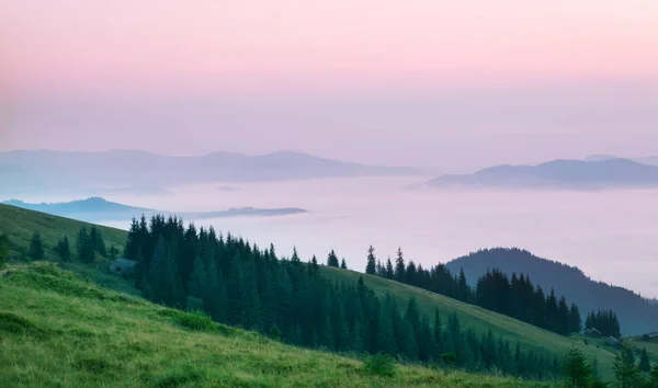 Pembe bulutlar üzerinde sabah dağlarda — Stok fotoğraf