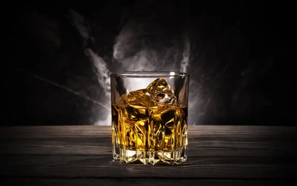 Glass of whiskey with ice on black background — Stock Photo, Image