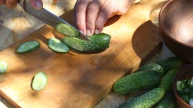 El salatalık kesme tahtası üzerinde kesmek.