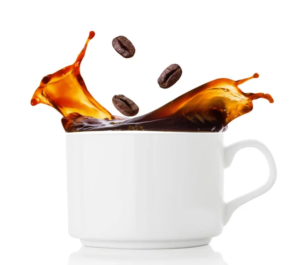 Coffee beans splash in cup of coffee — Stock Photo, Image