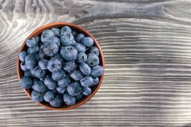 Böğürtlenler ahşap masada kil kasede