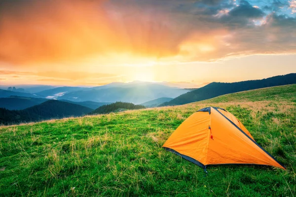 Oranje tent in de bergen bij zonsondergang — Stockfoto