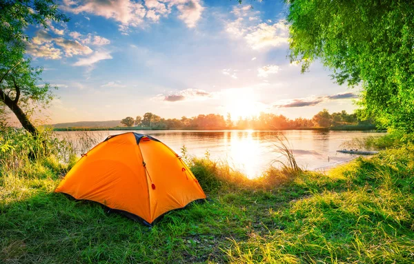 Orangefarbenes Zelt auf dem See bei Sonnenuntergang — Stockfoto