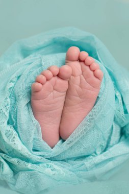 Yeni doğmuş bir bebek adımları turkuaz bir arka plan üzerinde