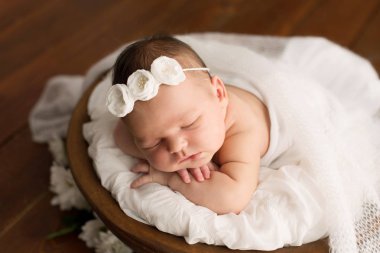 Yeni doğan kız papatya çiçekler bir kahverengi zemin üzerine. Yenidoğan için Photoshoot. doğumdan itibaren 7 gün. Güzel, yedi gün eski, yeni doğan bebek kız portresi