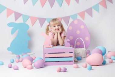 Paskalya ile şirin kız beyaz arka plan üzerinde yumurta. Yumurta ile kız oynamak. Paskalya yumurtaları renkli