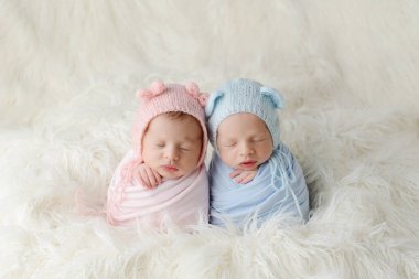 Uyuyan Newborn solungacı ve çocuk beyaz kürkün üzerinde yatıyor. Yeni doğan ikizler