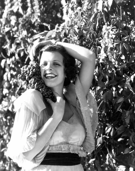保持彼女の顔の側面にあるブドウ畑の女性 — ストック写真