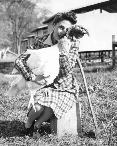女人抱着她的火鸡与斧头附近 — 图库照片