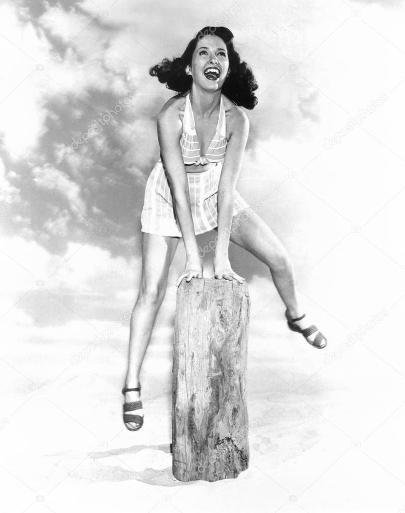 Young woman jumping over a hurdle