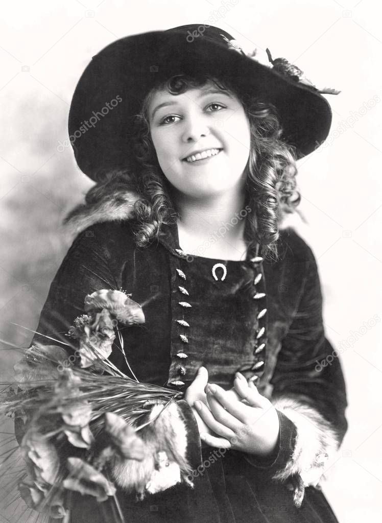 Girl wearing velvet dress and wide brim hat