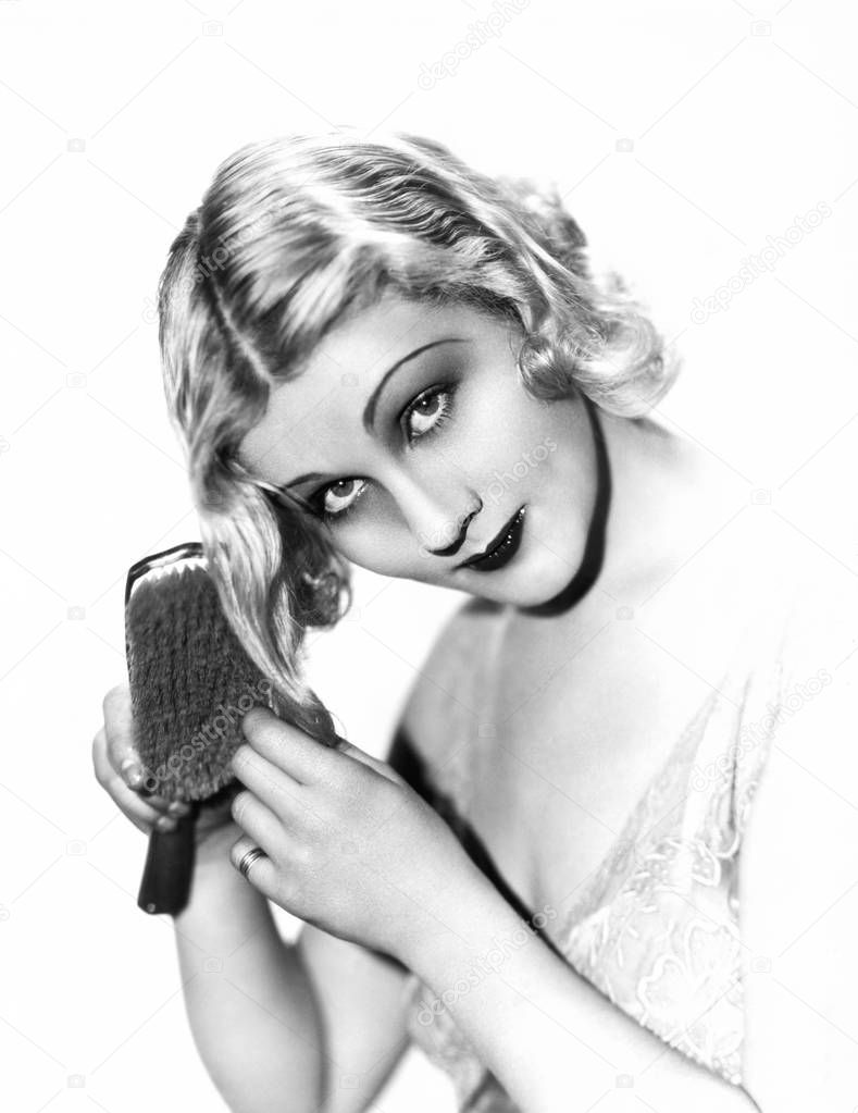 Blonde woman brushing her hair