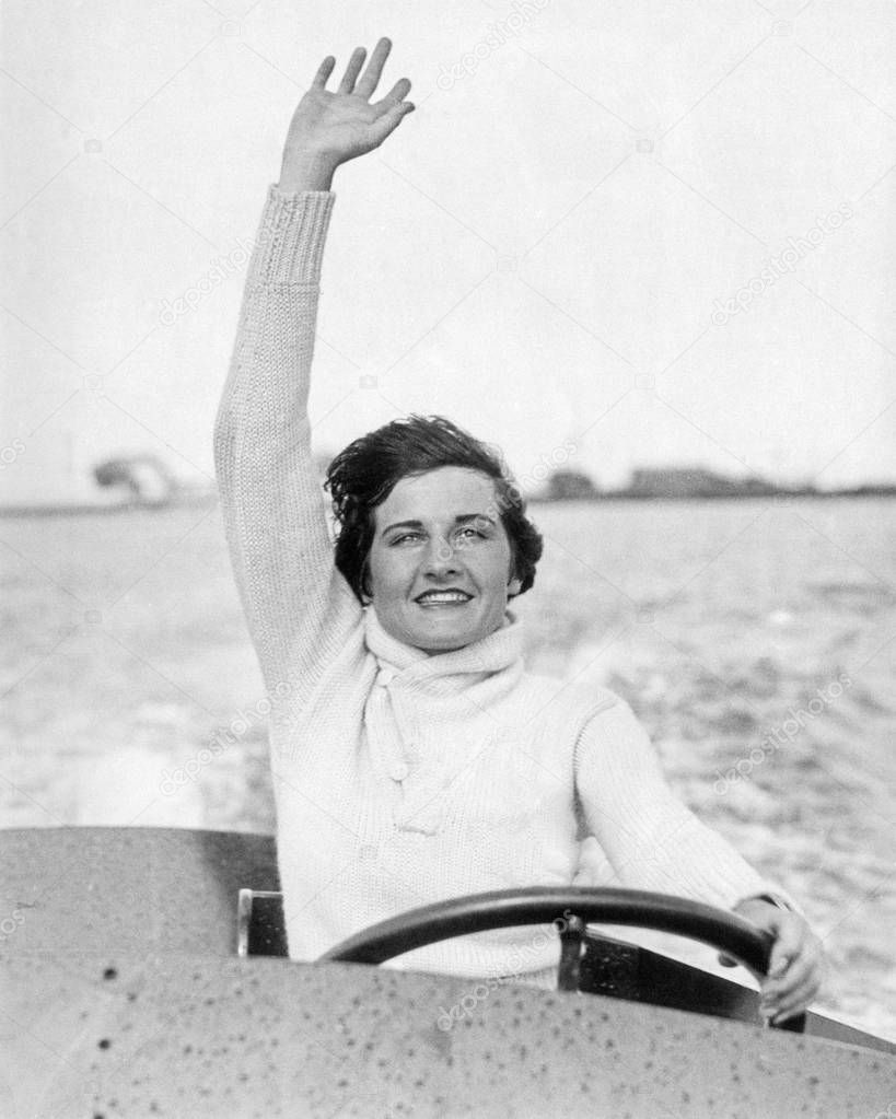 Woman waving from motor boat