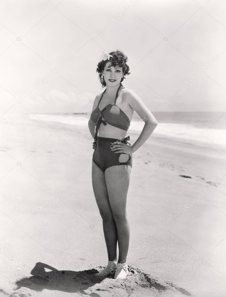 Woman in two-piece polka dot bathing suit posing on the beach