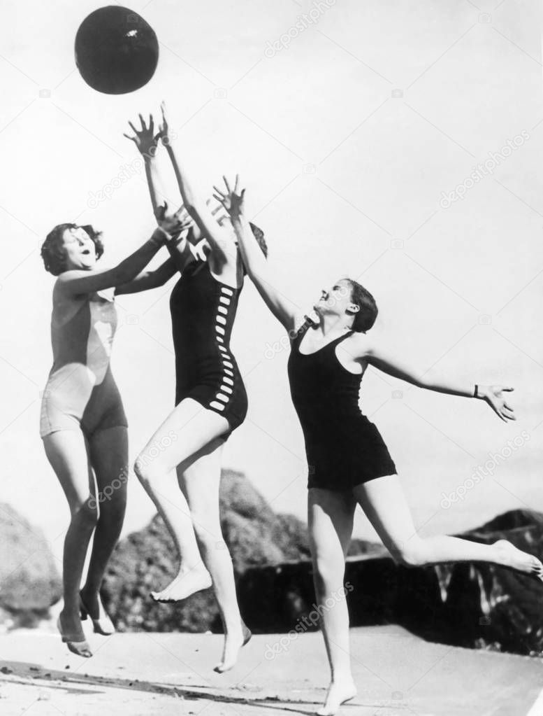 Three woman reaching for beach ball
